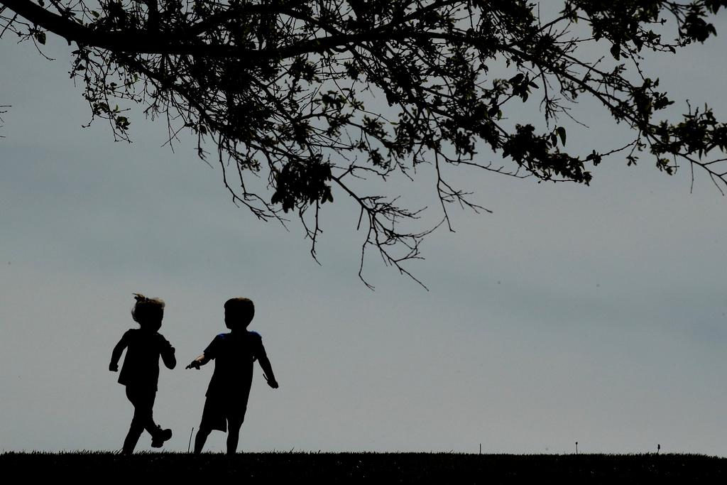 Children run on the lawn at the Liberty Memorial in Kansas City, Mo.