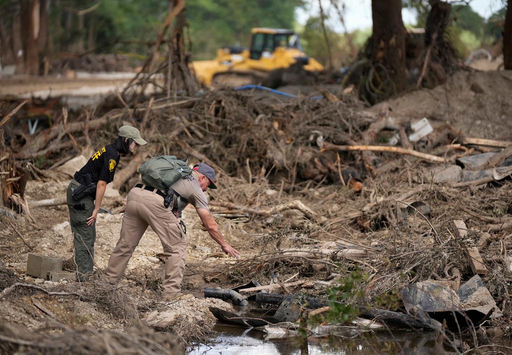Upton County sheriff deputies do search and recovery work on the banks of the Guadalupe River