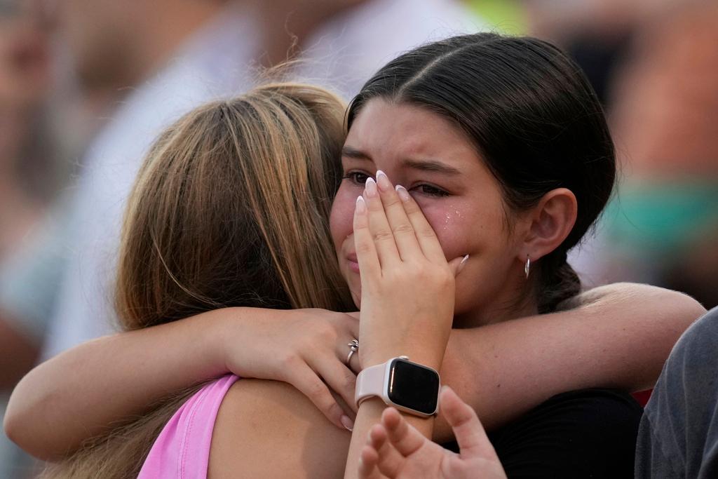 Girls hug during a vigil for flooding victims in Kerrville, Texas