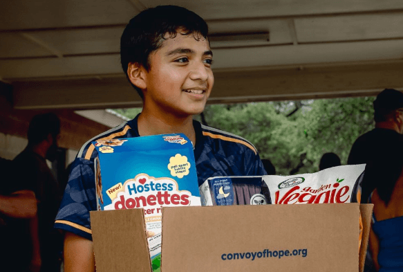 Young man holding a box full of snacks