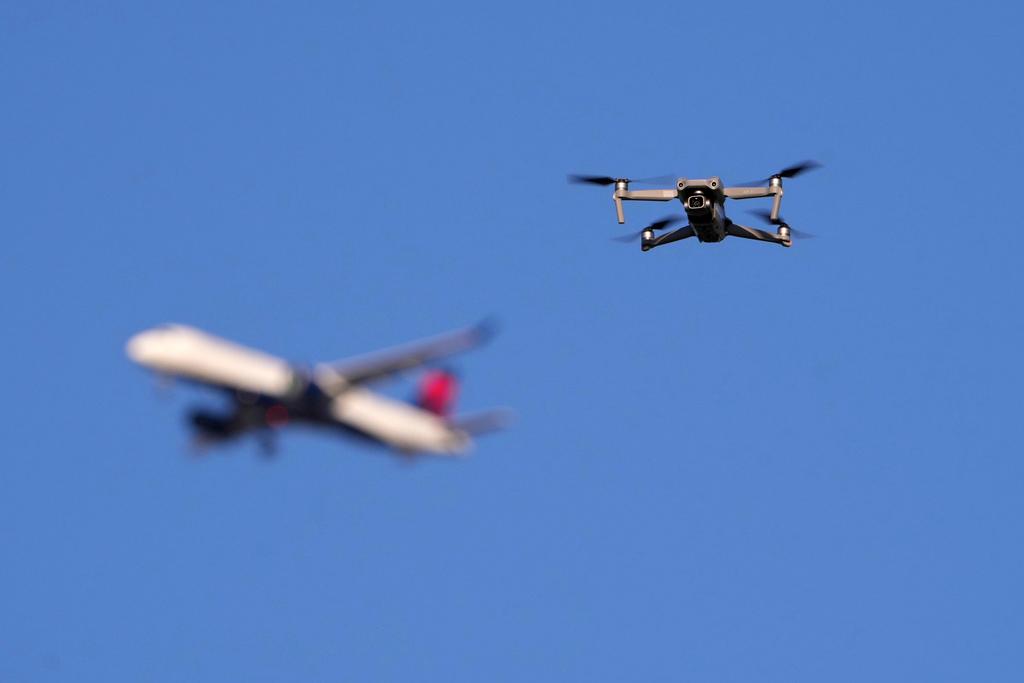 A drone hovers in airspace outside the safety perimeter surrounding St. Louis Lambert International Airport