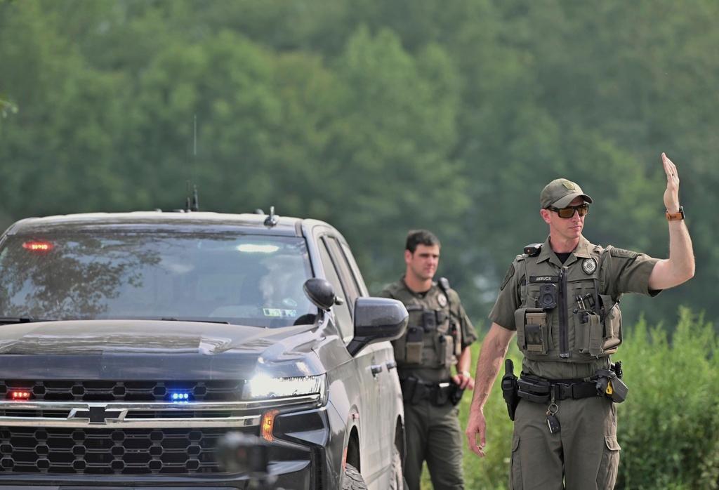 Police officers block the street leading to where two Pennsylvania state troopers were ambushed and shot