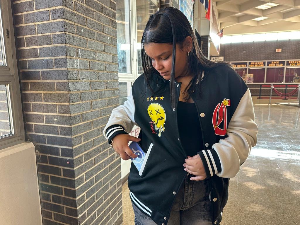 Doss High School student Mia Rivera puts her phone away before the start of school in Louisville, Ky. 
