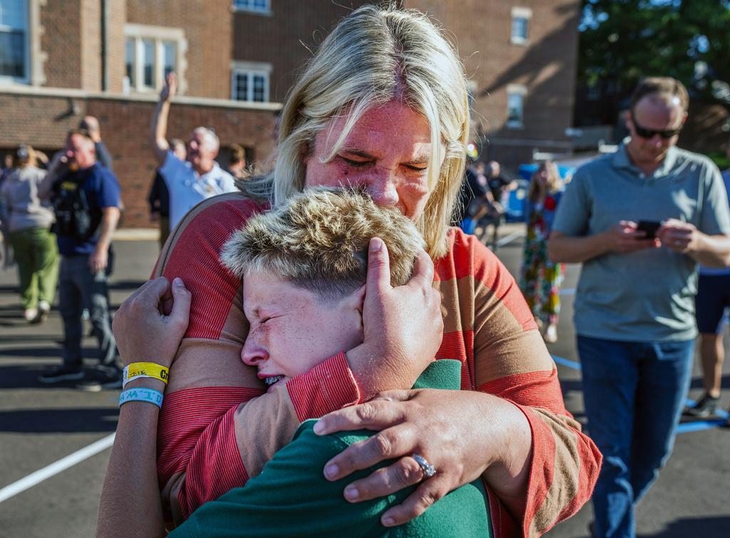 A parent hugs her son during an active shooter situation at the Annunciation Church in Minneapolis