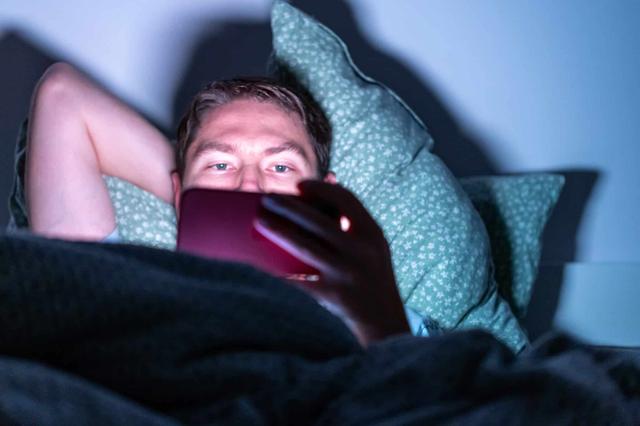Dude in bed with phone