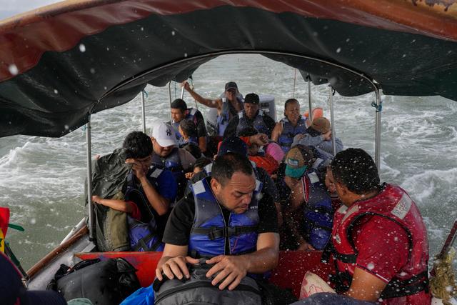 Luis Sanchez, center, sits with other Venezuelan migrants on a boat leaving Gardi Sugdub on Panama's Caribbean coast after giving up hopes of reaching the U.S. while in southern Mexico