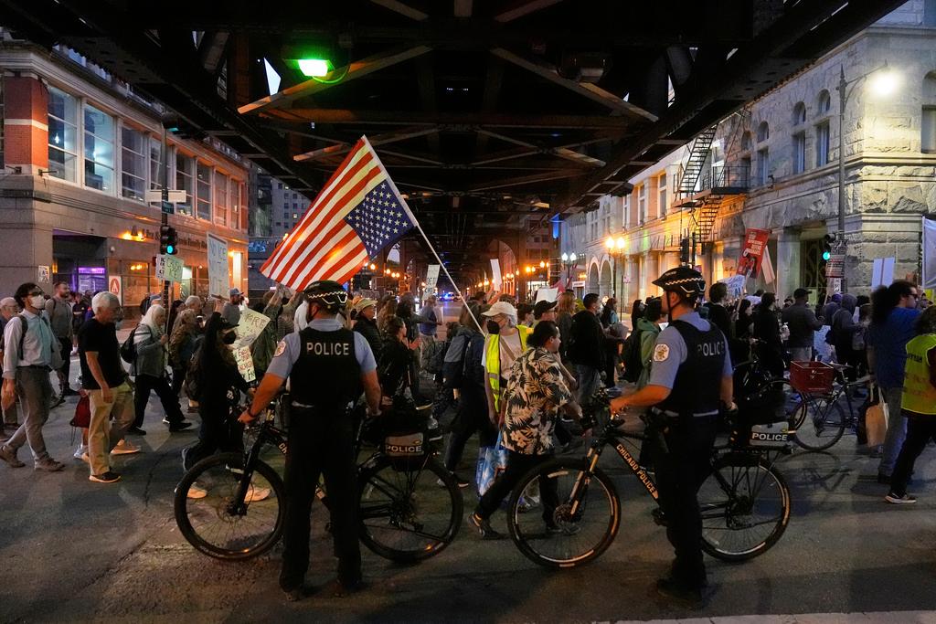 Police officers block a street as demonstrators march at a protest opposing "Operation Midway Blitz" and the presence of ICE in Chicago