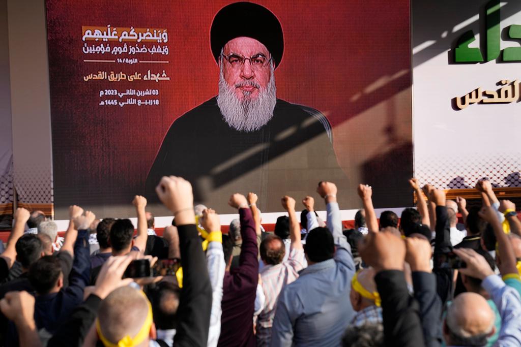 Supporters of the Iranian-backed Hezbollah group raise their fists and cheer as Hezbollah leader Sayyed Hassan Nasrallah appears via a video link, during a rally to commemorate Hezbollah fighters who were killed in South Lebanon 