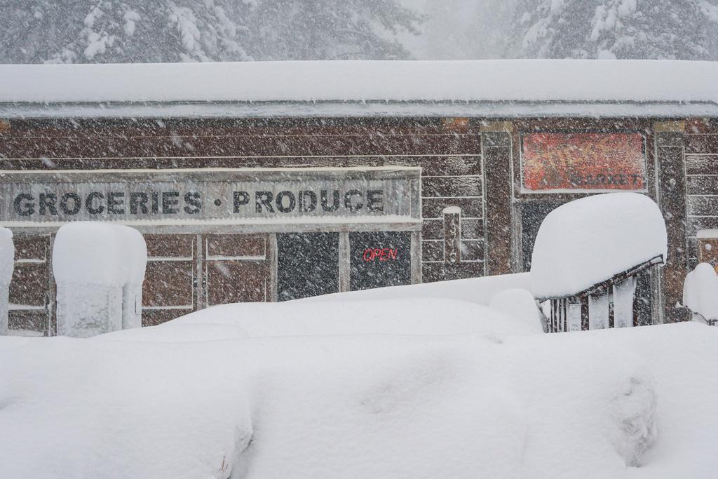 Snow covers the landscape in front of a store, during a storm in Truckee, Calif.