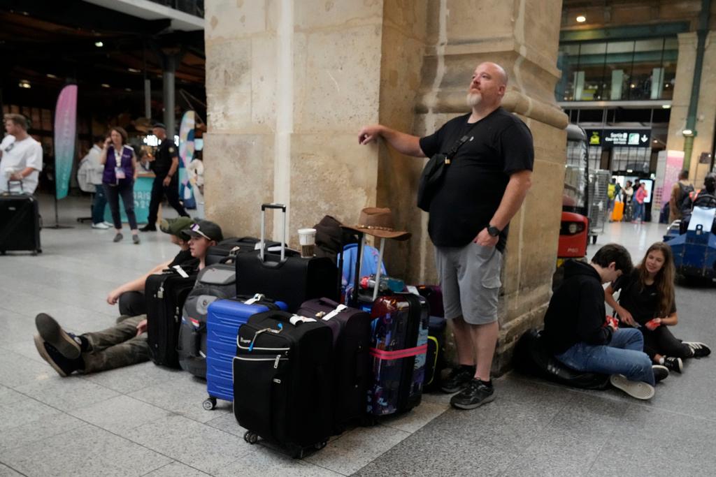 Travelers wait inside the Gare du Nord train station at the 2024 Summer Olympics, Friday, July 26, 2024, in Paris, France. Hours away from the grand opening ceremony of the Olympics, high-speed rail traffic to the French capital was severely disrupted on Friday by what officials described as "criminal actions" and sabotage.