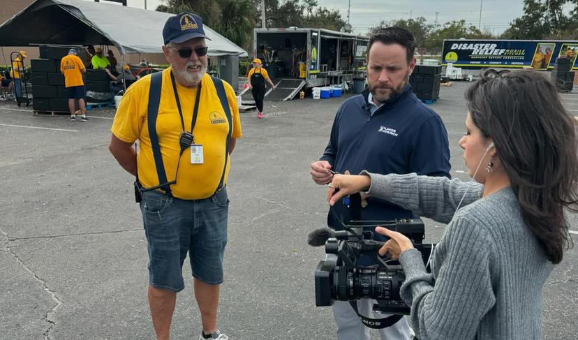 Two men, woman with TV camera