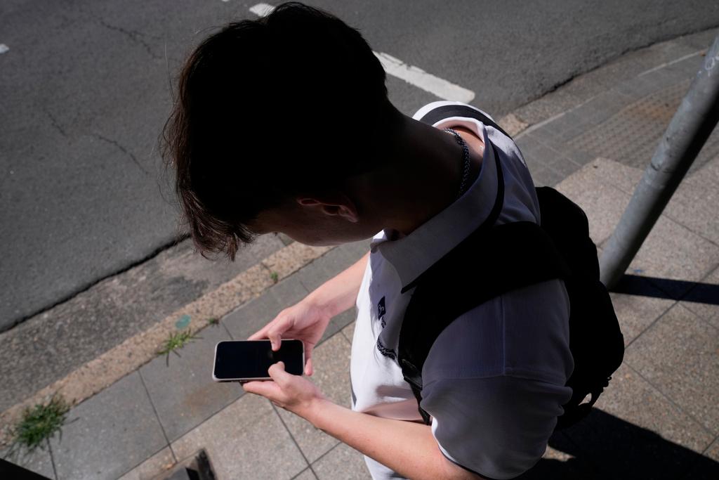  teenage boy uses his smartphone