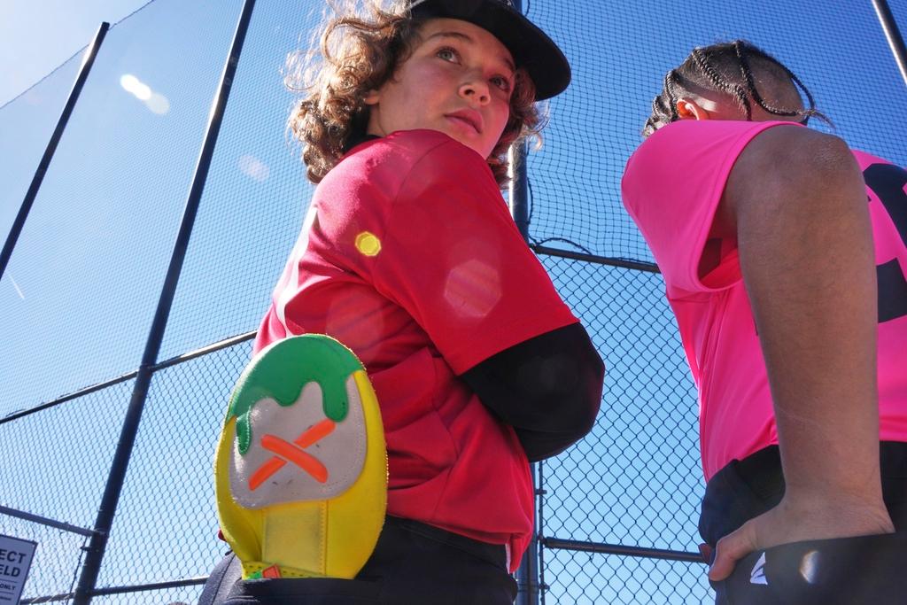 Youth ballplayer Grayson Cole, left, waits for his game to get underway with his Savannah Banana sliding mitt in his back pocket