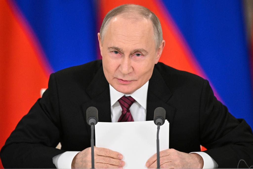 Russian President Vladimir Putin gestures as he speaks to journalists in the Grand Palace at the Kremlin in Moscow