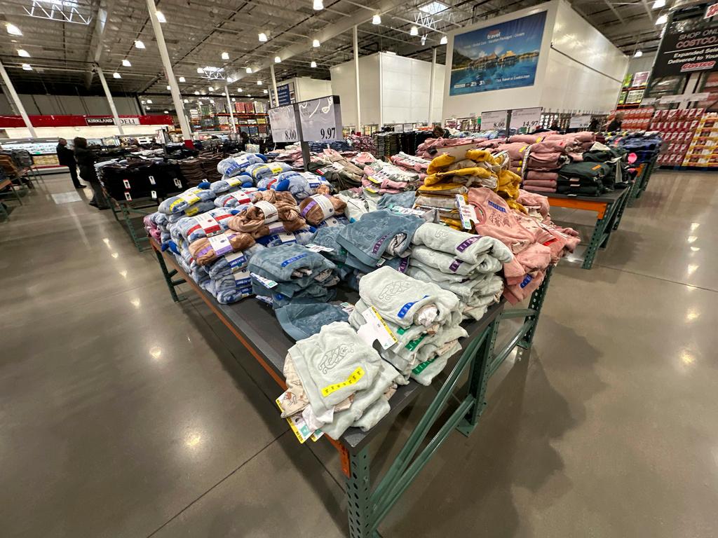 Children's clothing sits stacked on a table for shoppers in a Costco warehouse 