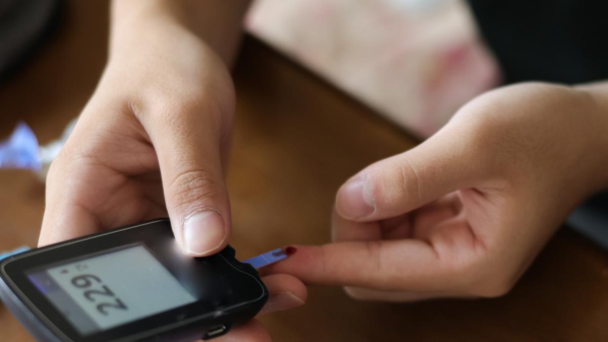 Young hands holding a blood sugar meter