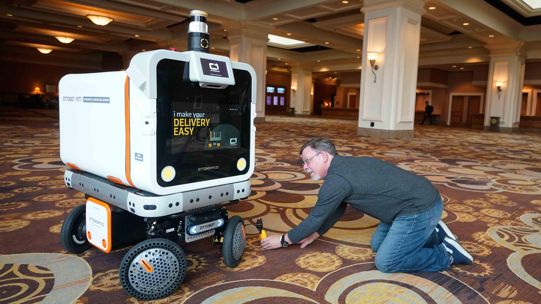 A member of the media films the Ottobot Yeti as it operates before the start of the CES tech show, Wednesday, Jan. 4, 2023, in Las Vegas.