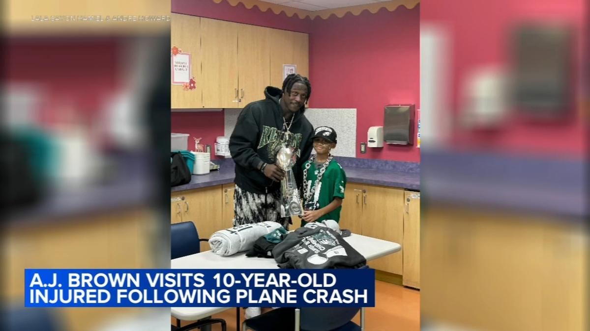 Eagles football player with trophy and little boy at the hospital